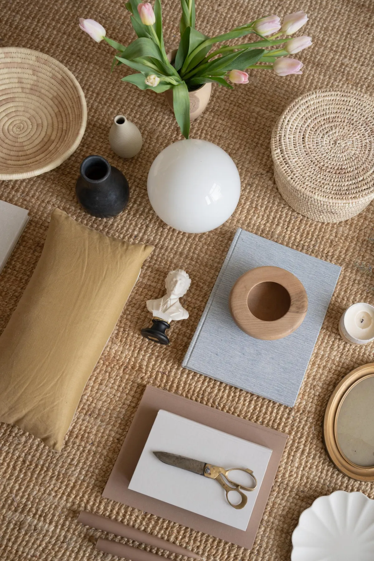 Flat-lay of curated home decor pieces and natural materials — soft earthy tones, intentional styling, and grounded interior aesthetic