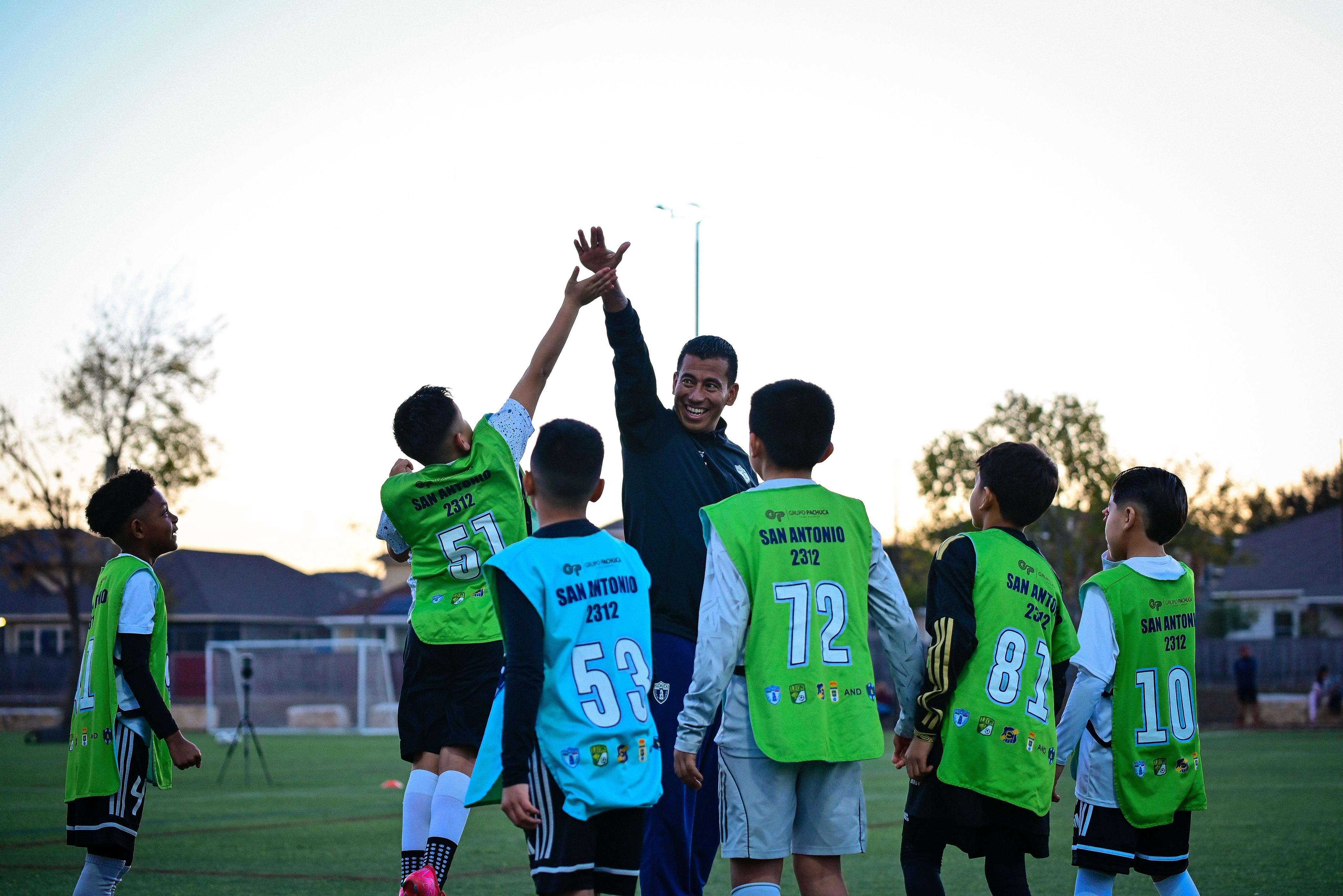 Kids playing soccer with a coach during practice