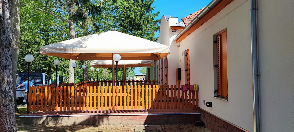Napernyővel fedett terasz fából készült kerítéssel