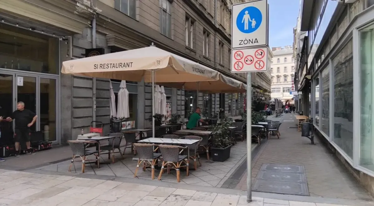 Utcai étterem terasza bézs logózott napernyőkkel