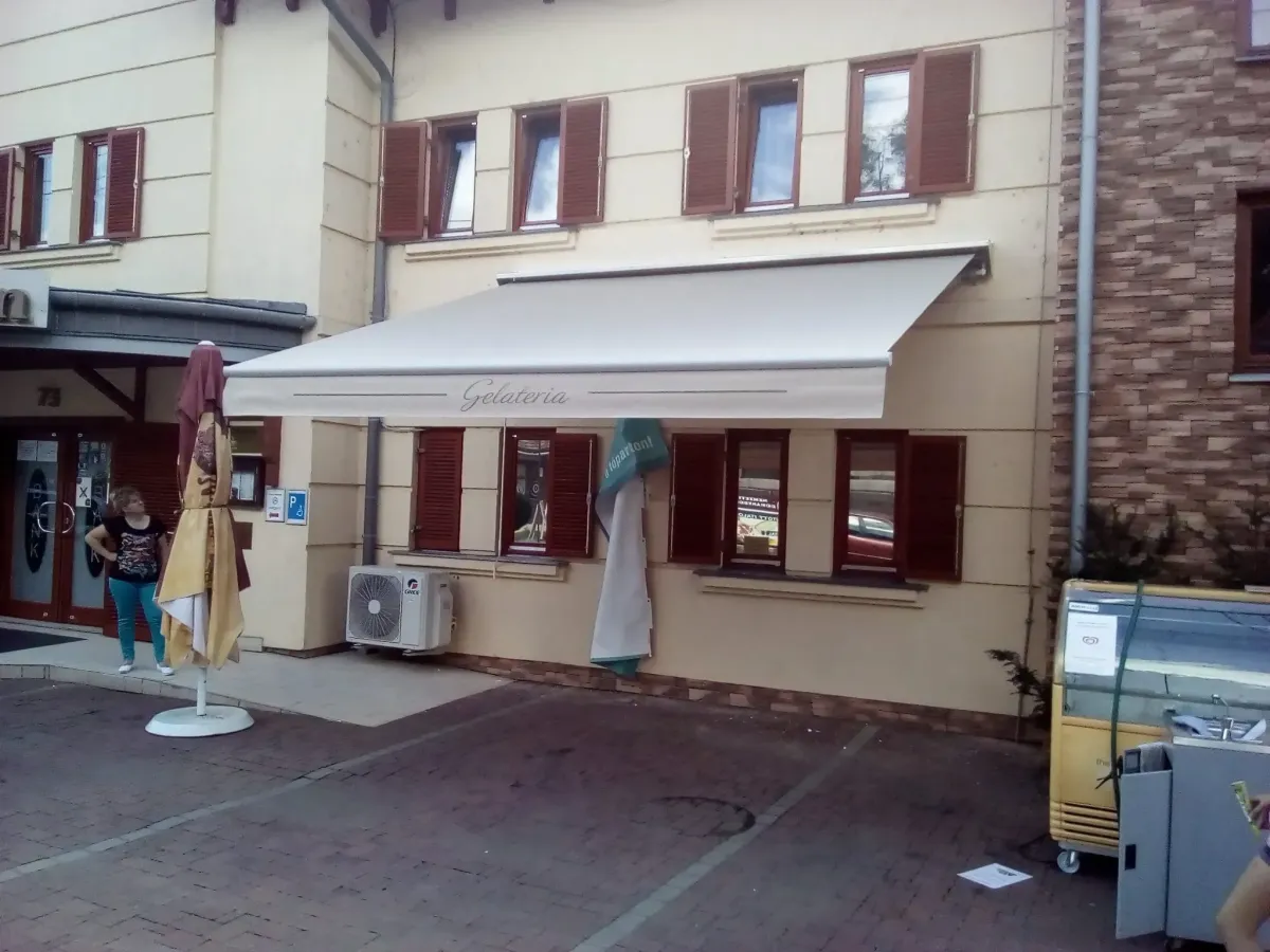 Fagylaltozó bejárata fehér napellenzővel árnyékolva