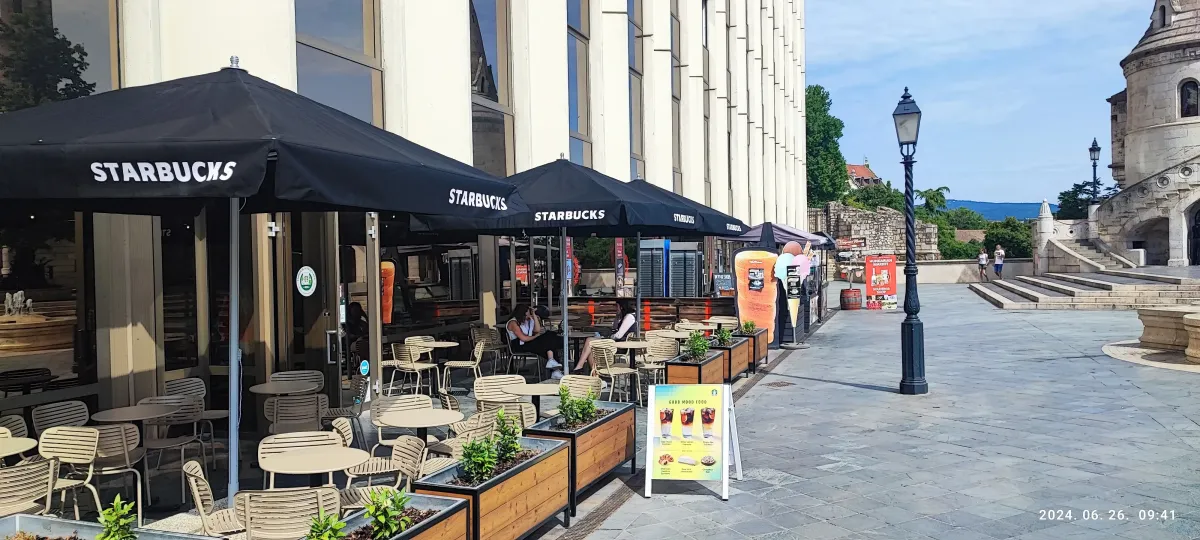 Starbucks terasz fekete logózott napernyőkkel a városközpontban