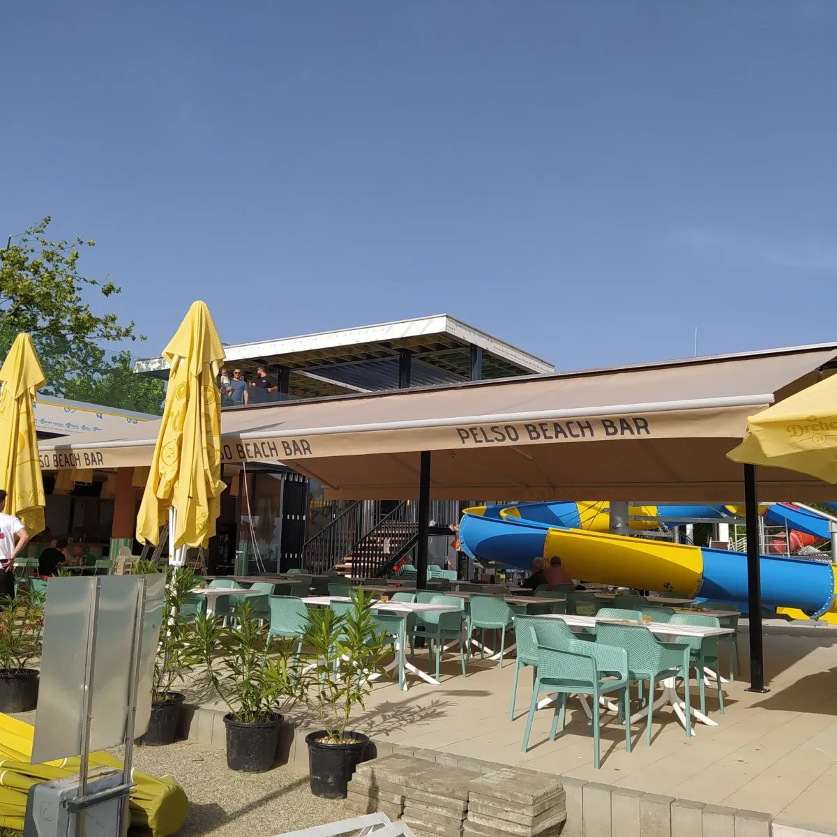 Pelso Beach Bar feliratos napellenzők és napernyők egy strandbüfé teraszán