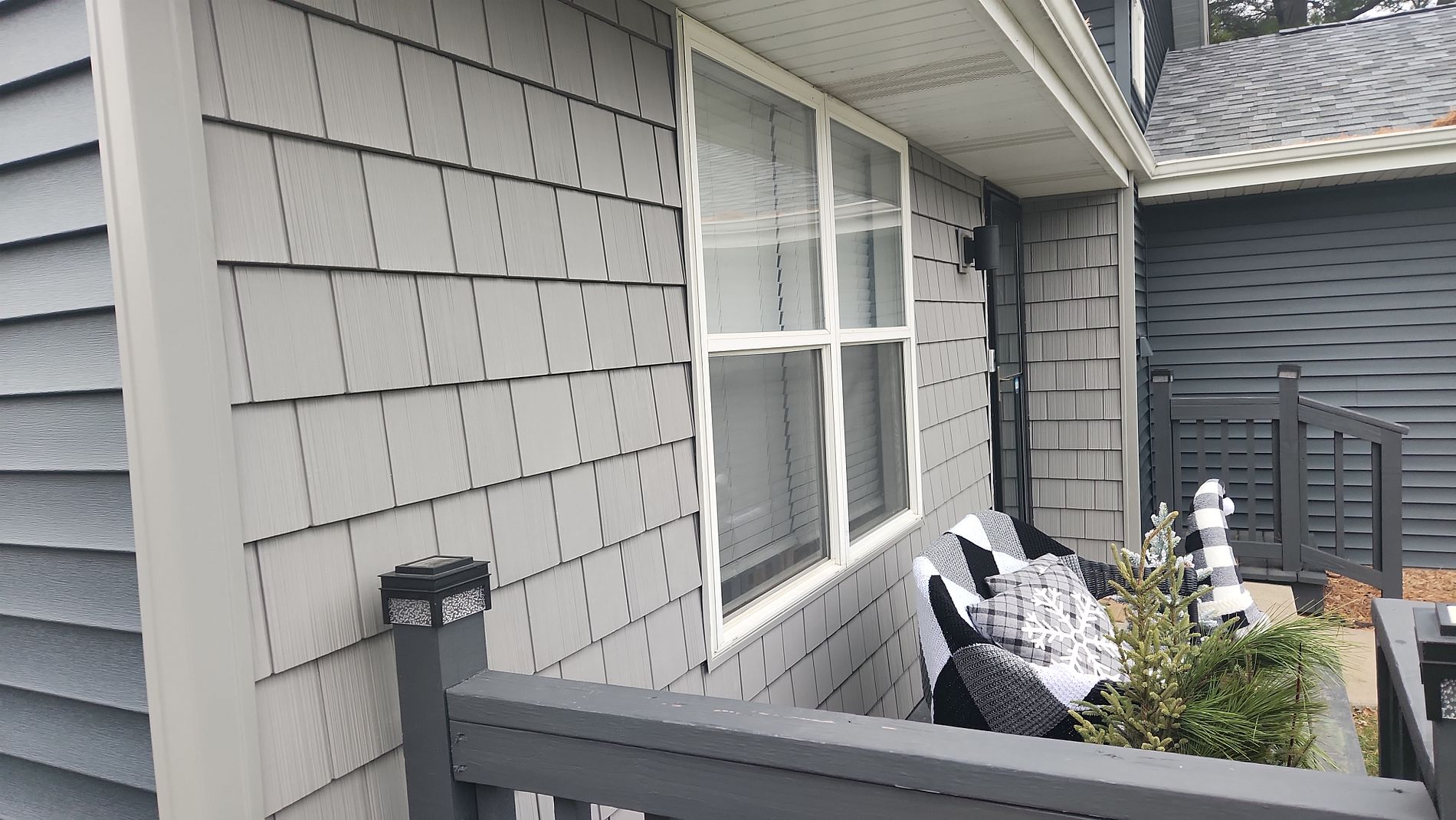 Vinyl lap siding with J-channel trim above a garage door under fascia metal on a two-story home in Machesney Park Illinois