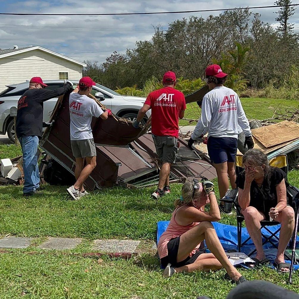 Volunteers loading boxes into a van wearing safety vests during a community distribution event.