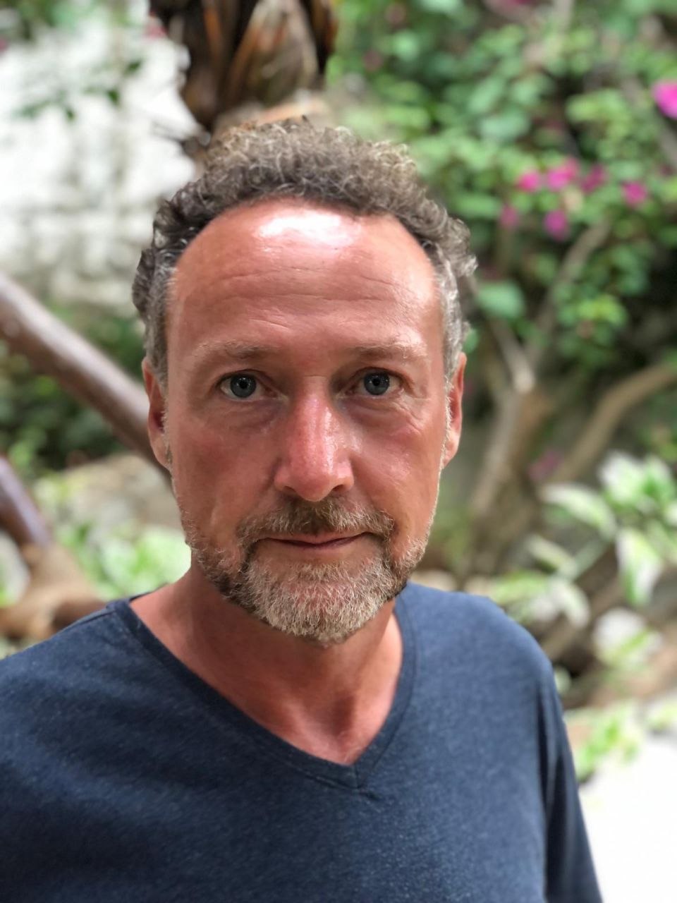 Coach lächelnd mit Kind auf dem Arm – professionelles Portrait