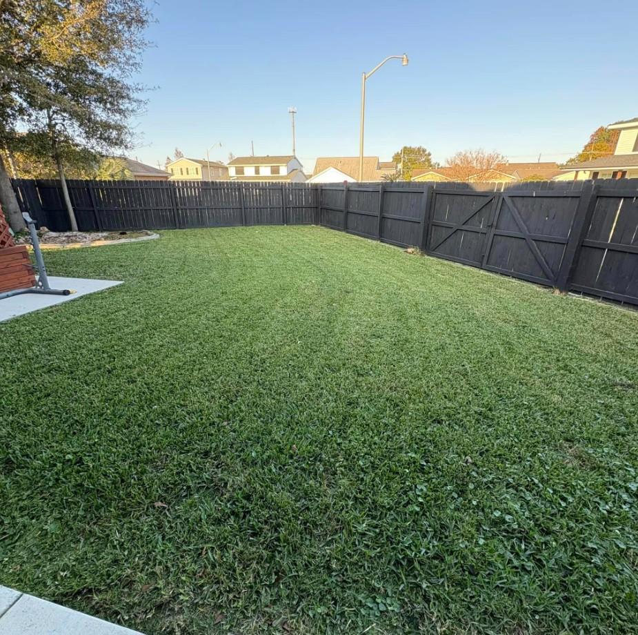 Wide backyard in Avondale LA displaying uniform mowing pattern and clean finish