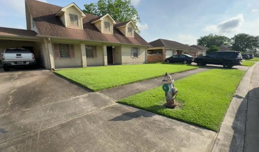 Lush green front lawn in Avondale LA after professional lawn care service