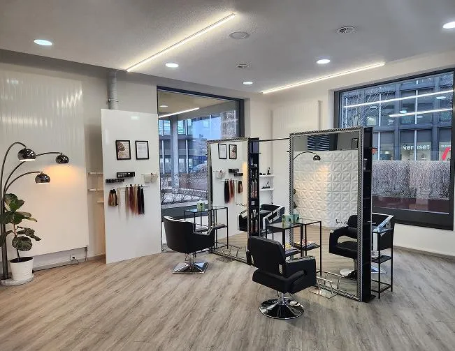 Moderner Innenraum des Glücksschere Friseursalons in Pratteln mit gemütlichem Bereich für Kundinnen