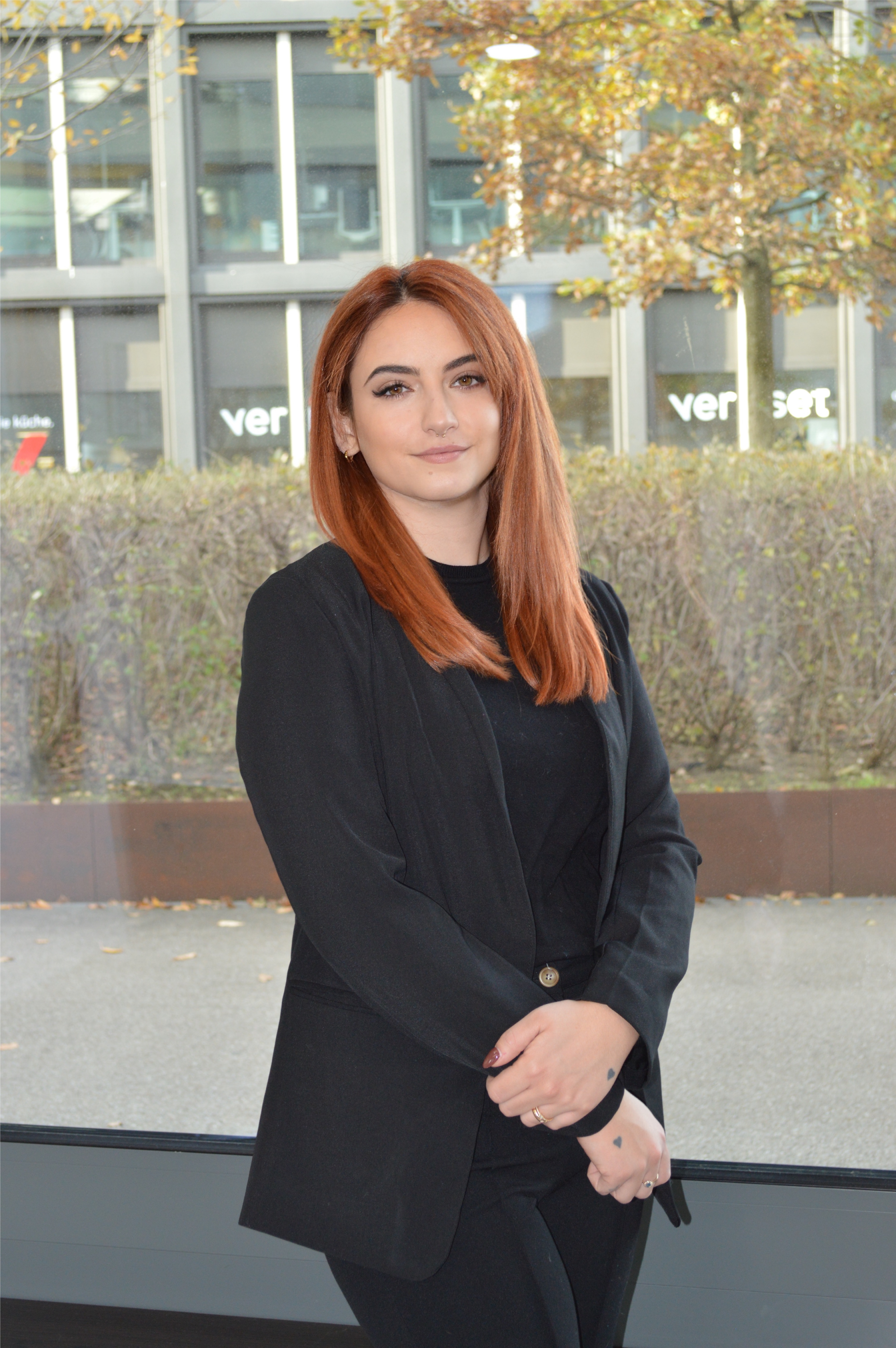 Friseurin Laura vor dem Schaufenster mit Herbstkulisse in Pratteln