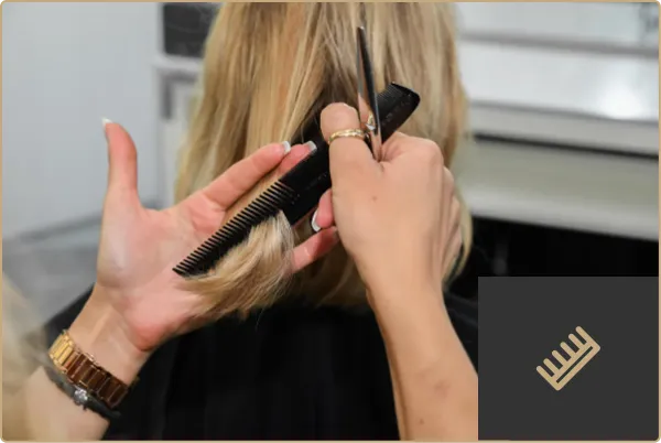 Friseurin schneidet Haare mit Schere am Oberkopf