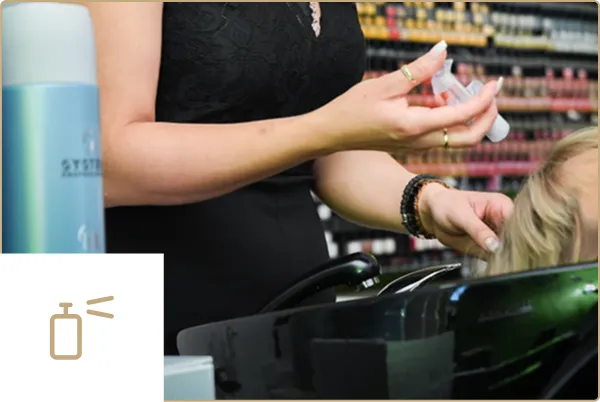 Friseurin hält Pflegeprodukte im Salon