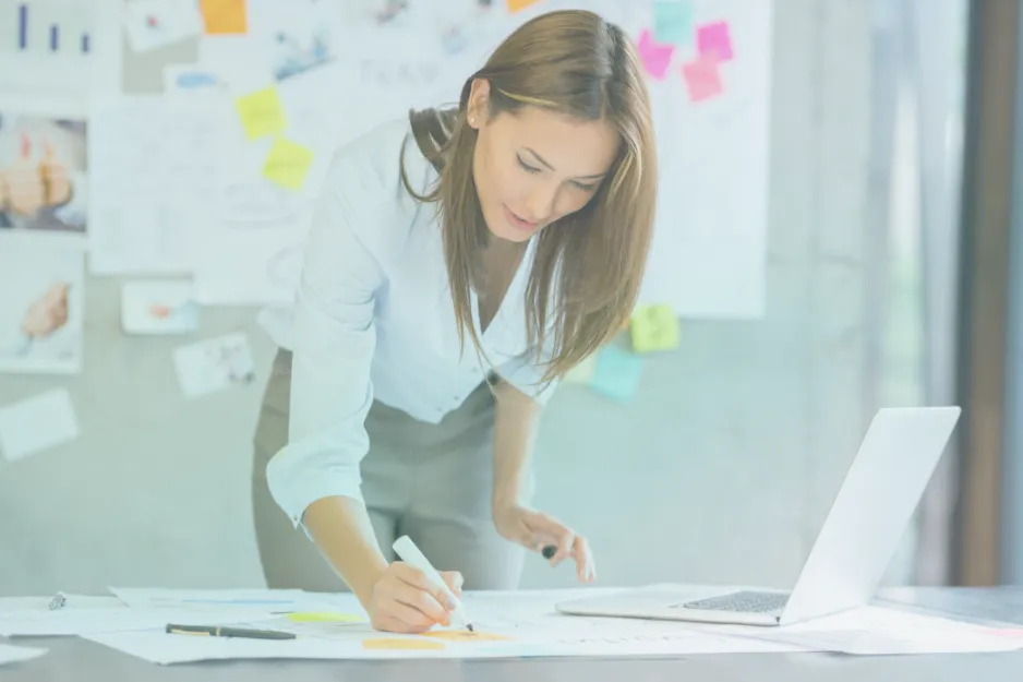 Woman writing notes while working at a desk