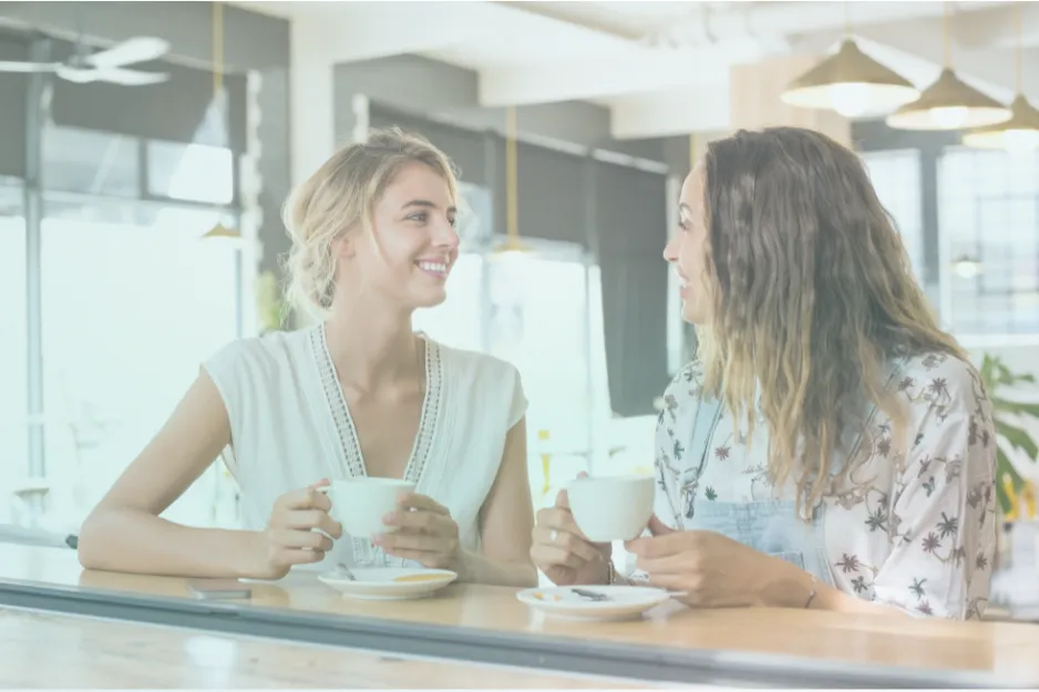 Two women talking over coffee at a table