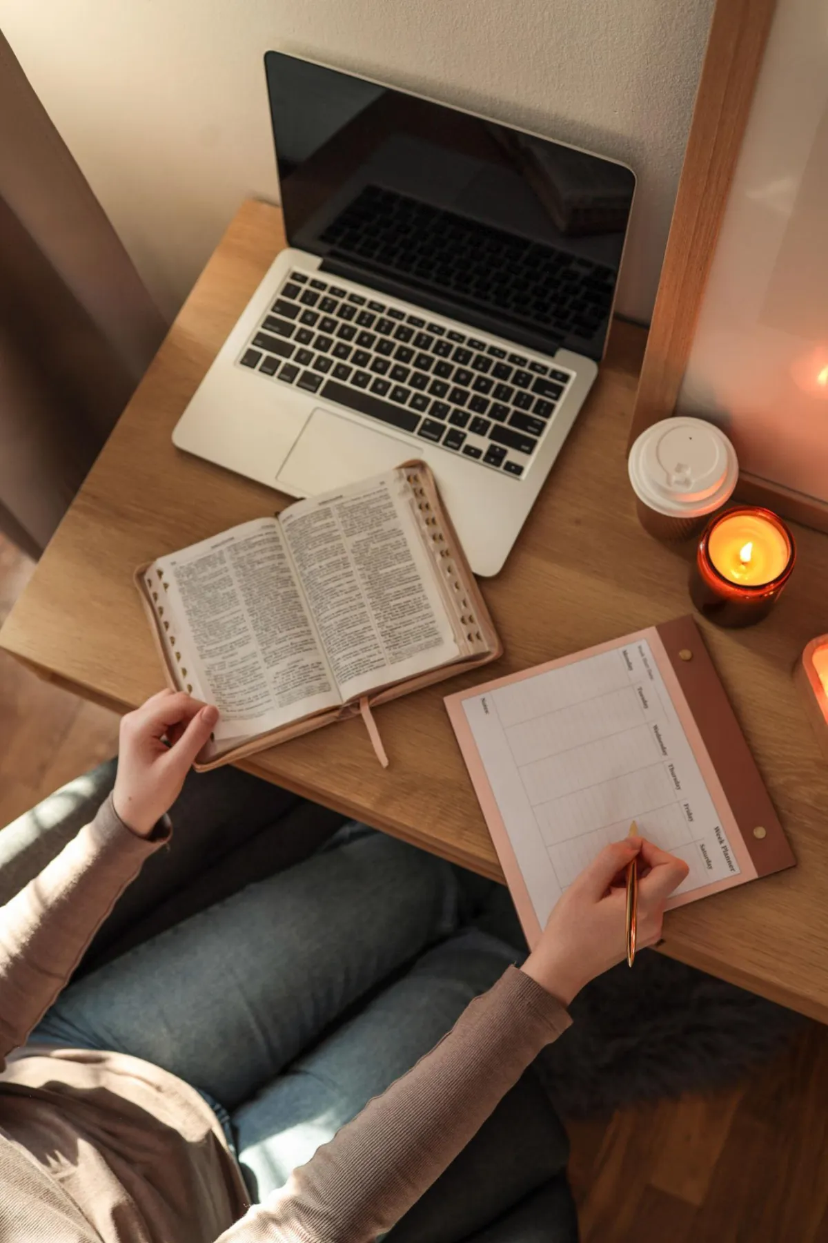 Woman studying the Bible while writing notes at her desk