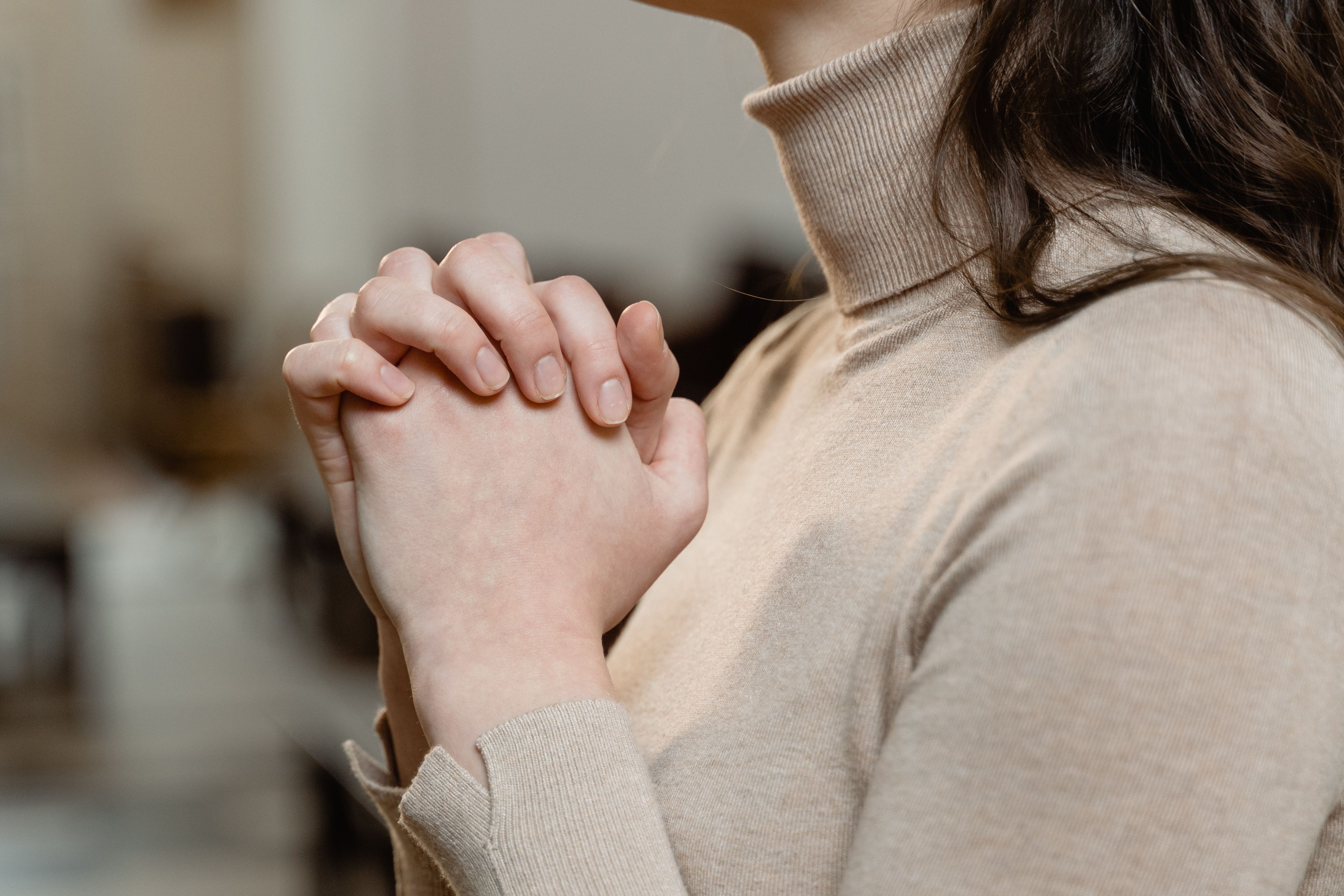 Woman with hands clasped in prayer