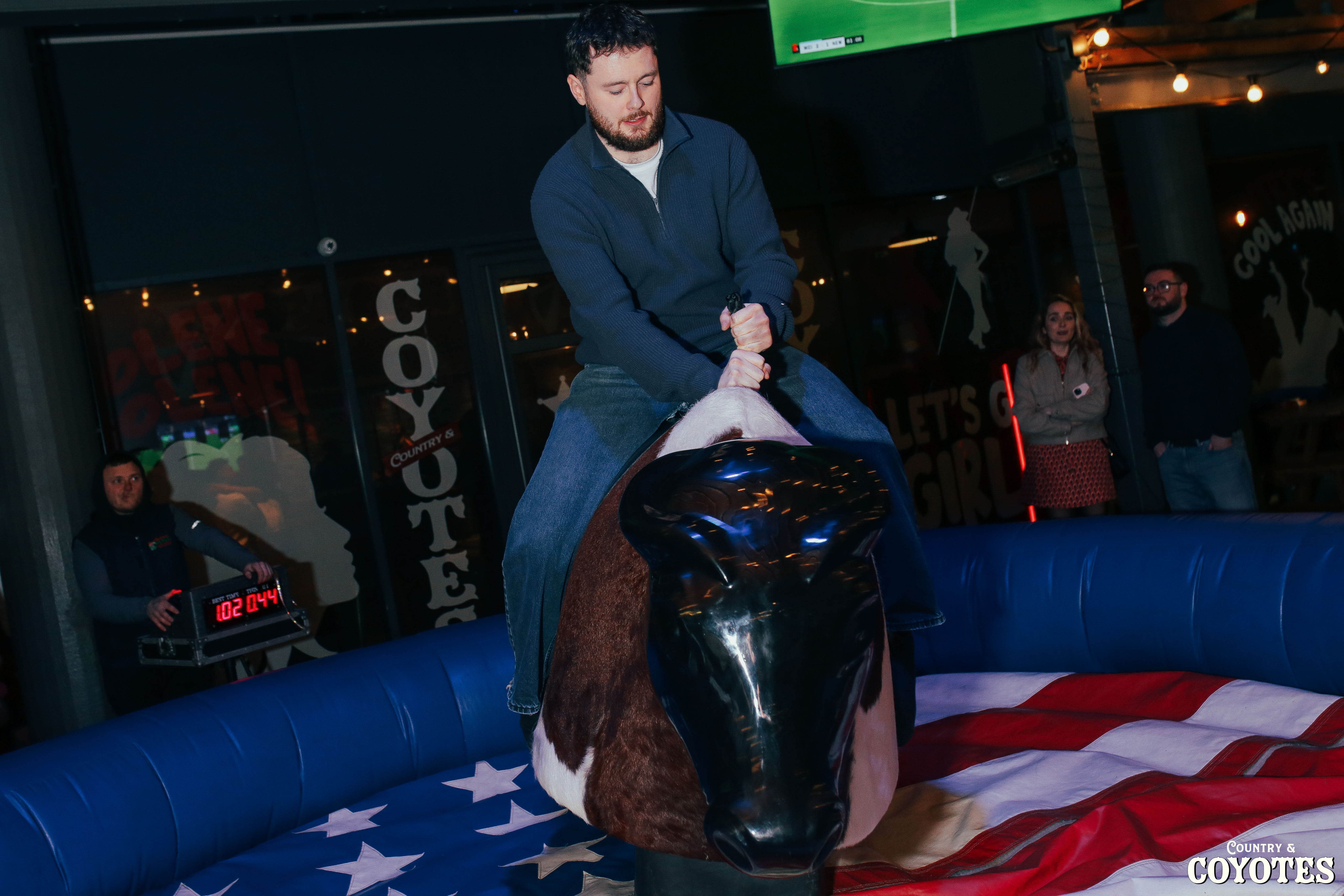 Daytime party at Cowgirls & Country, crowds singing and drinks flowing