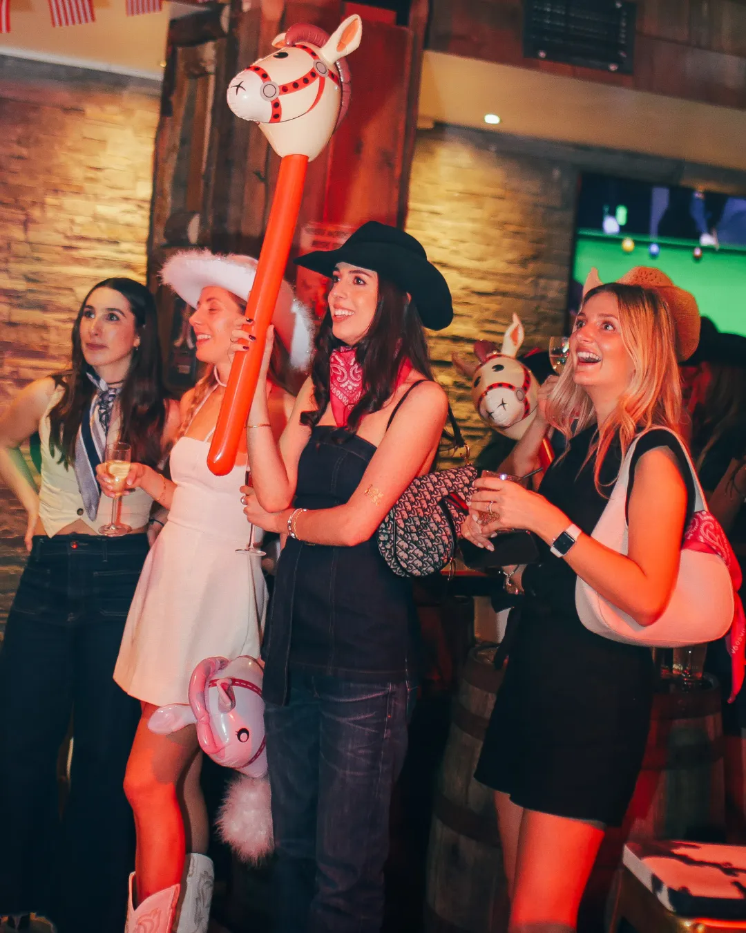 Wild group party with high-contrast amber lighting and cowboy hats
