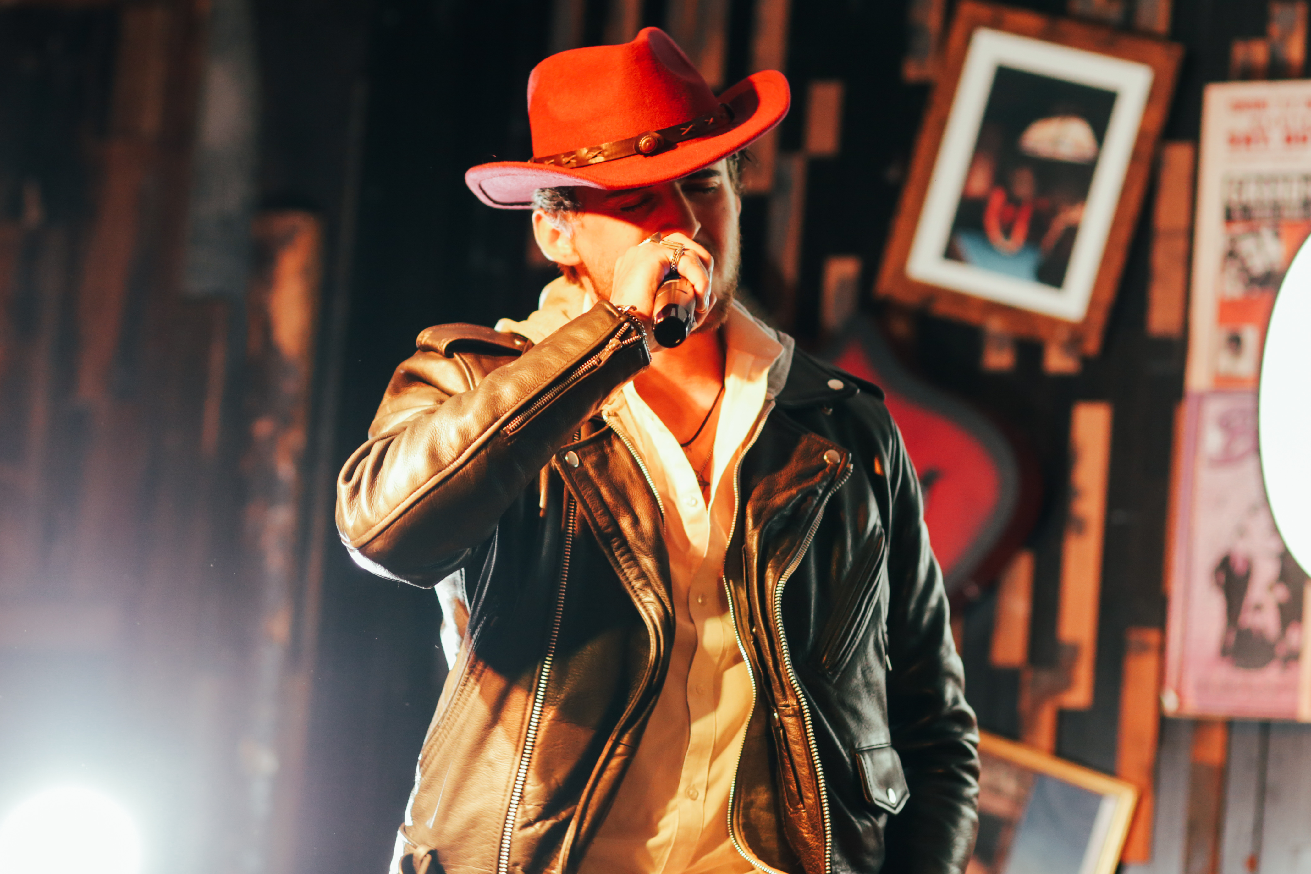 Live tribute artist on stage with warm lighting at Cowgirls & Country
