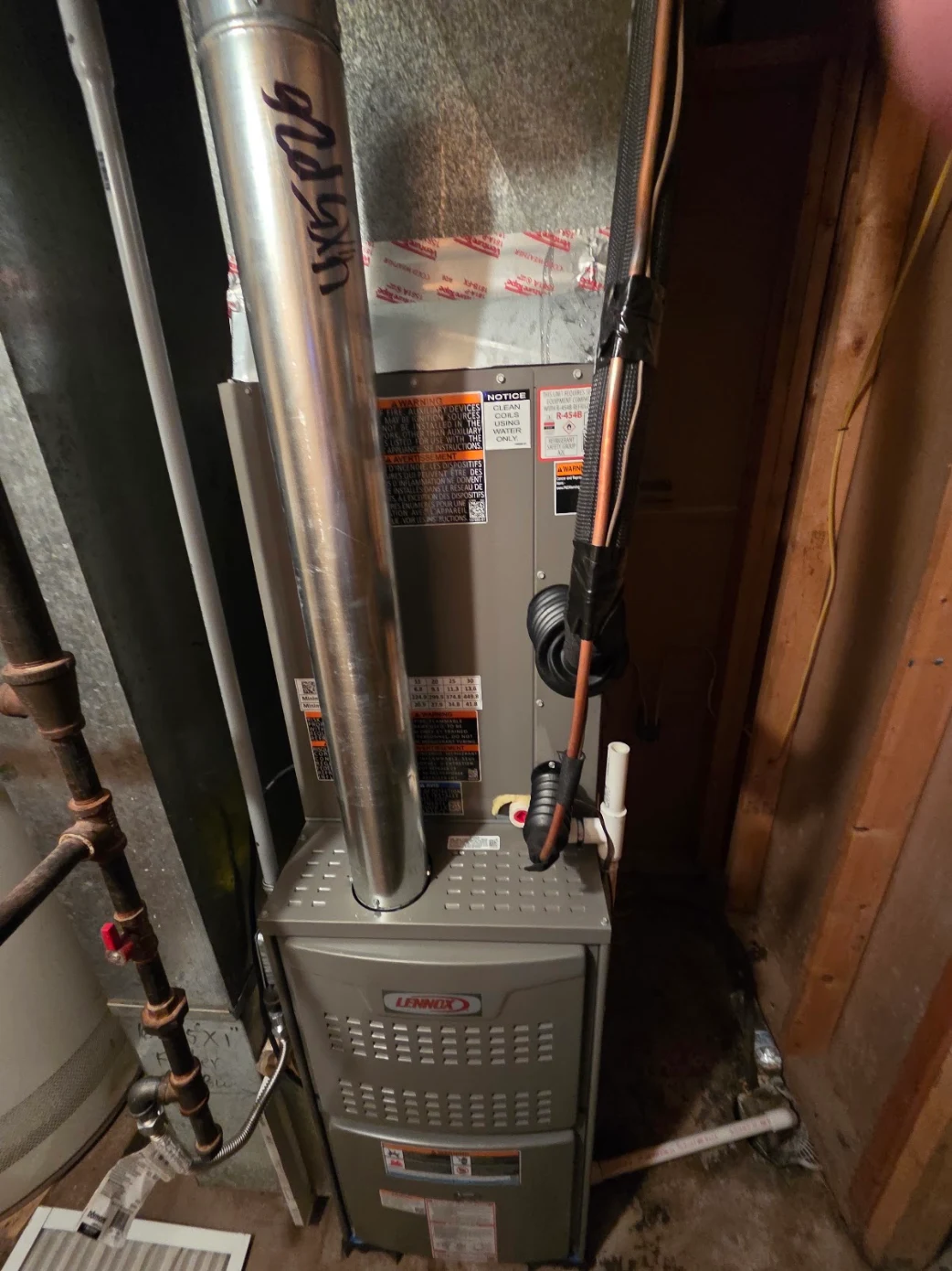A brand new Lennox furnace and high-efficiency evaporator coil installed in a basement utility closet in Lenexa, Kansas.