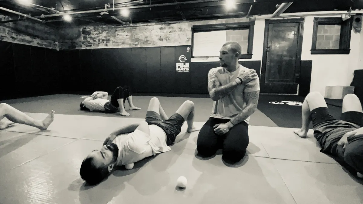 Group floor-practice session with a coach demonstrating an upper-body position