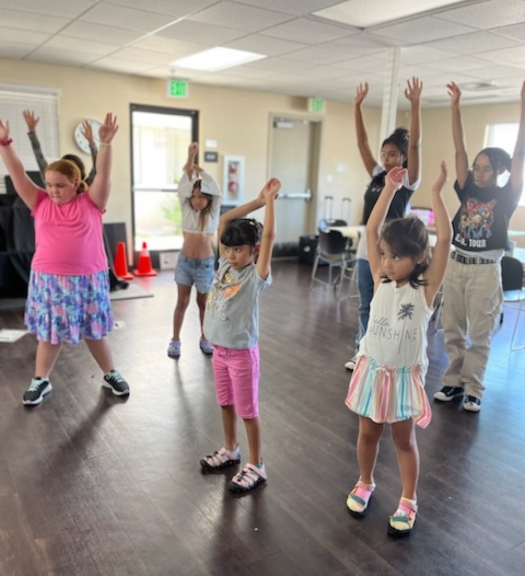 Kids moving with the teacher on a large screen TV