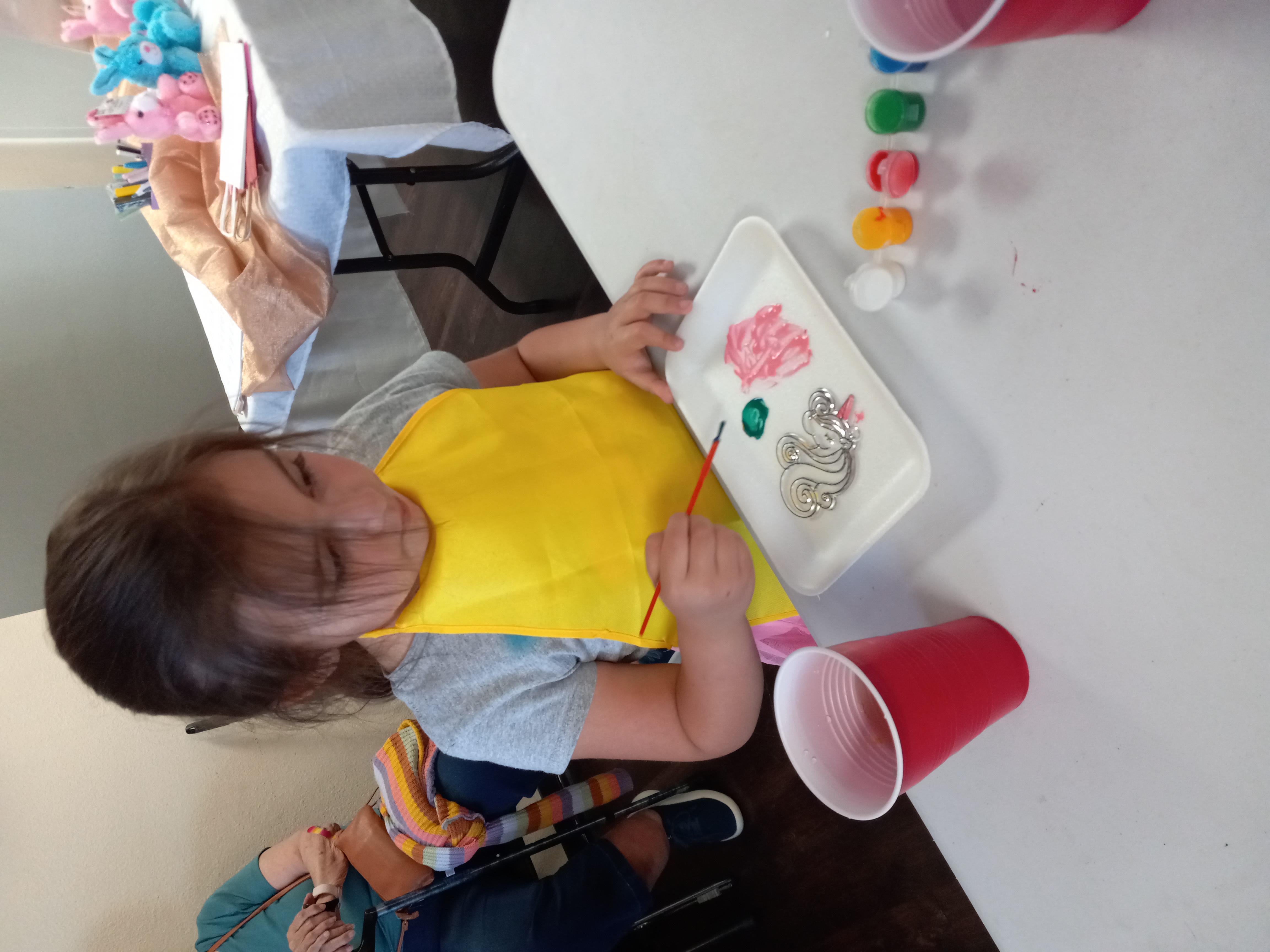 Students sit in a semicircle watching the teacher on a laptop