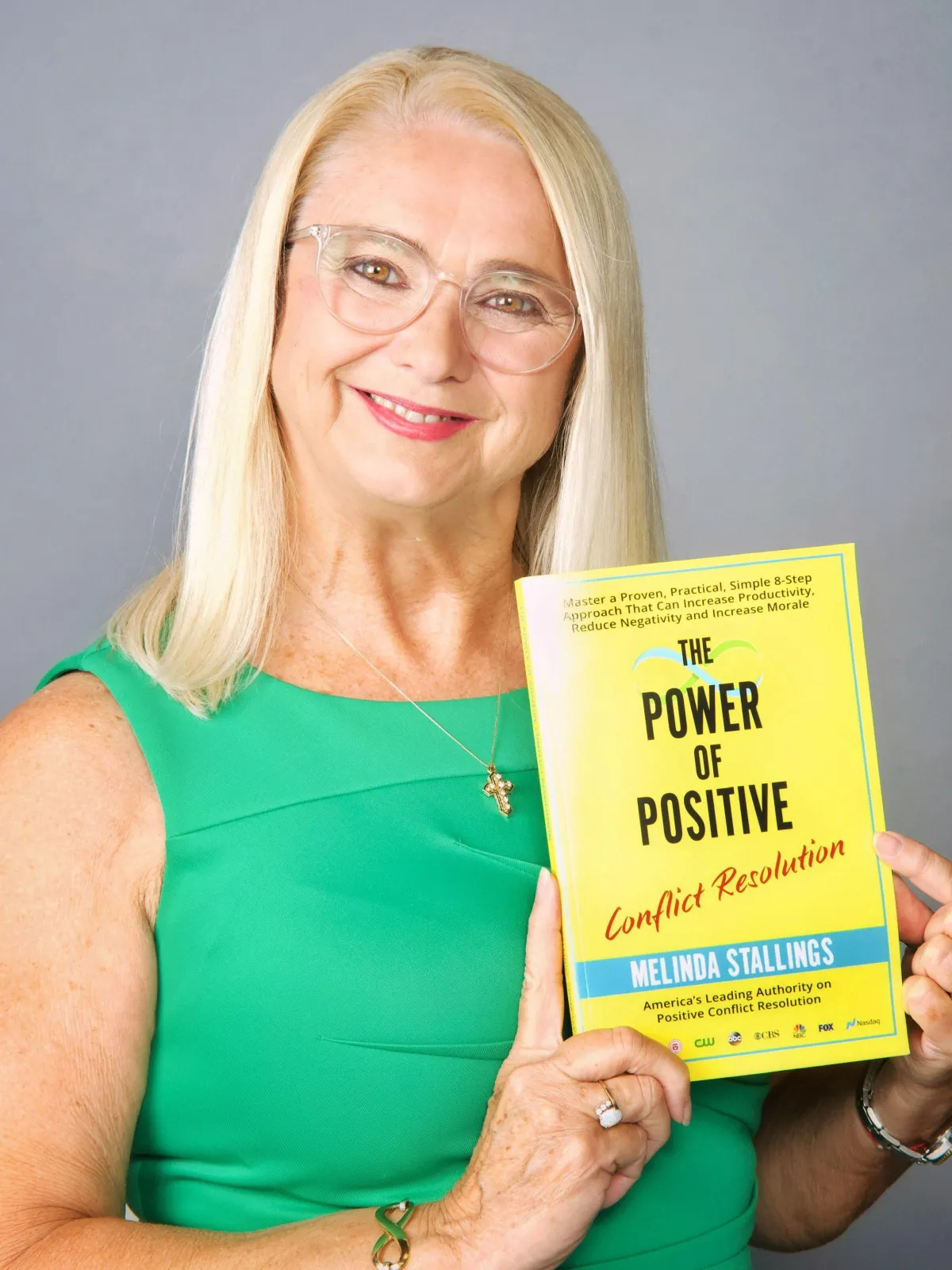 Melinda Stallings holding her best-selling book 'The Power of Positive Conflict Resolution'