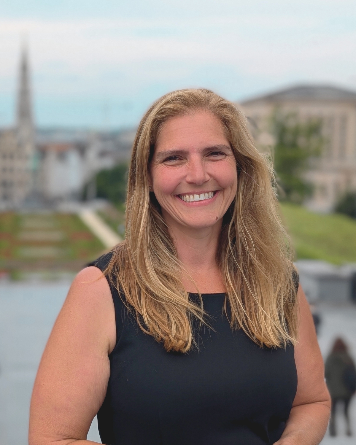 Professional headshot of Jennifer Guerrero, an award-winning Colorado Springs real estate agent and Nathan Johnson Team member, featured against a city backdrop.
