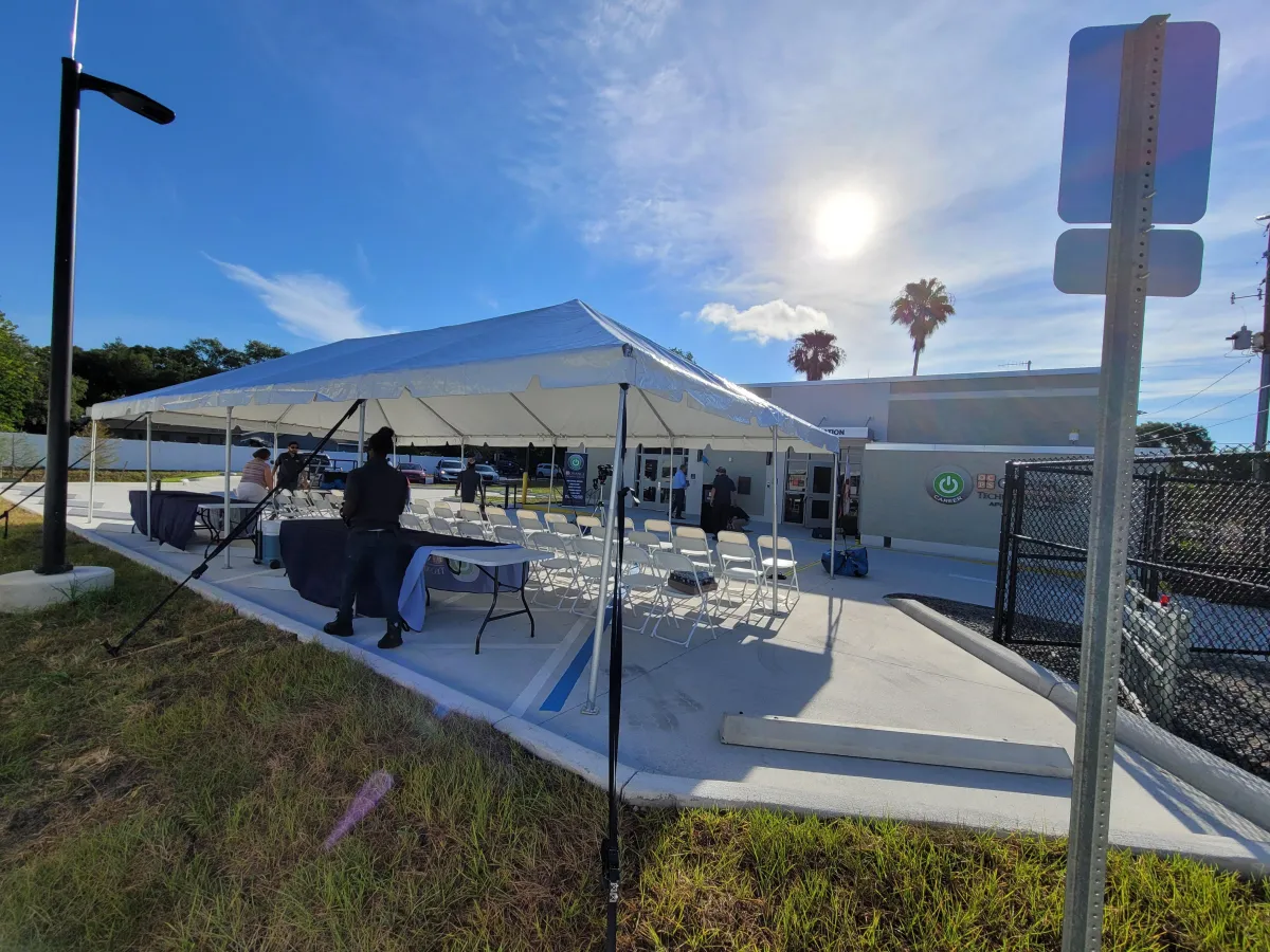 Large event tent with community seating and tables set up for guests