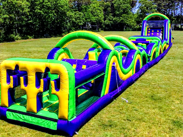 An outdoor obstacle course setup with climbing and inflatable elements for active play