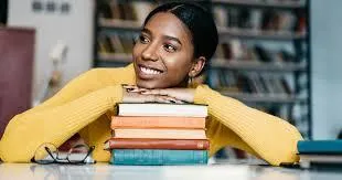 person holding pencil near laptop computer