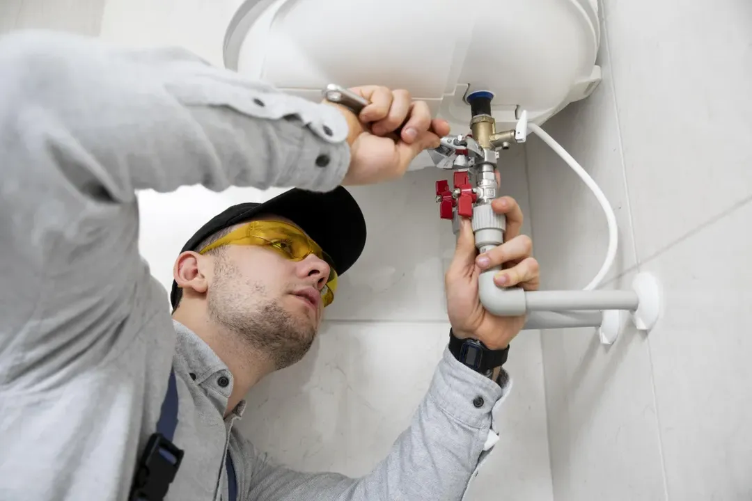 Plumber from Lion Plumbing repairing and installing a residential water heater with professional tools.