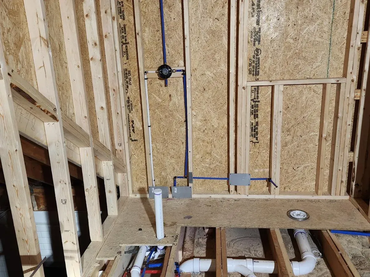New construction plumbing rough-in with PEX water lines and PVC drain system installed in framed bathroom — professional plumbing installation by Lion Plumbing