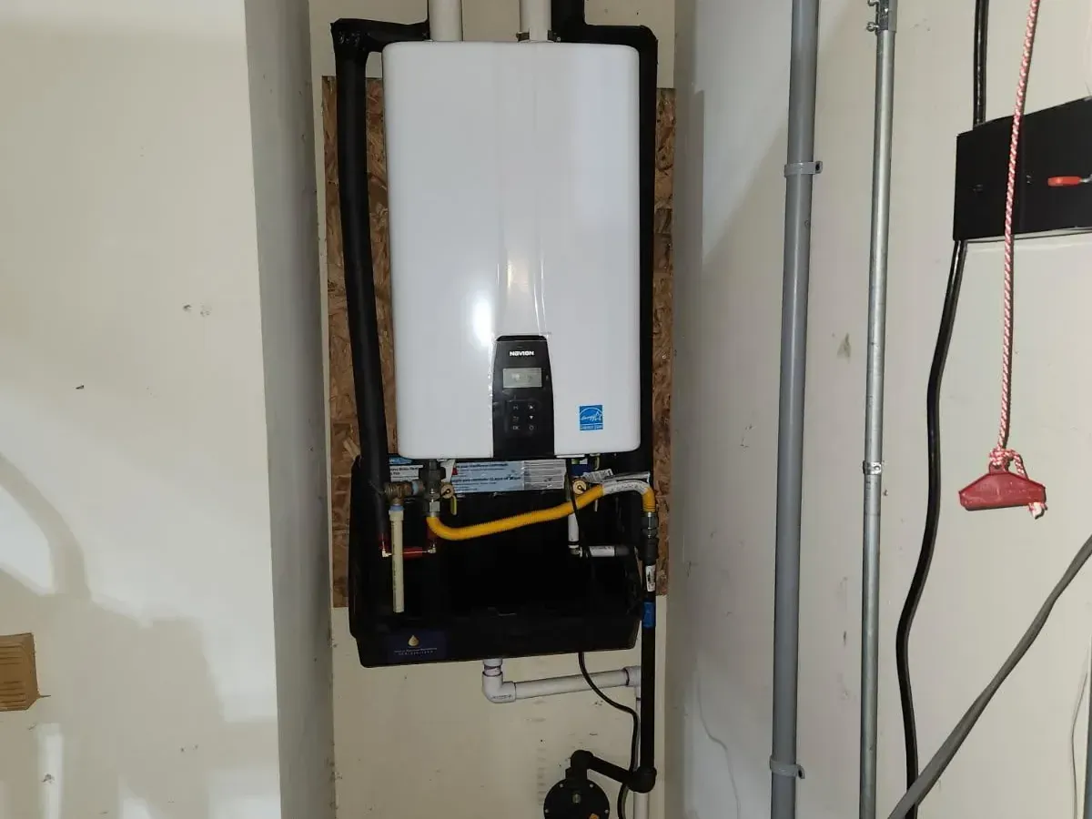 Tankless water heater installation with clean gas and PVC venting in a residential utility area — expert tankless system setup by Lion Plumbing
