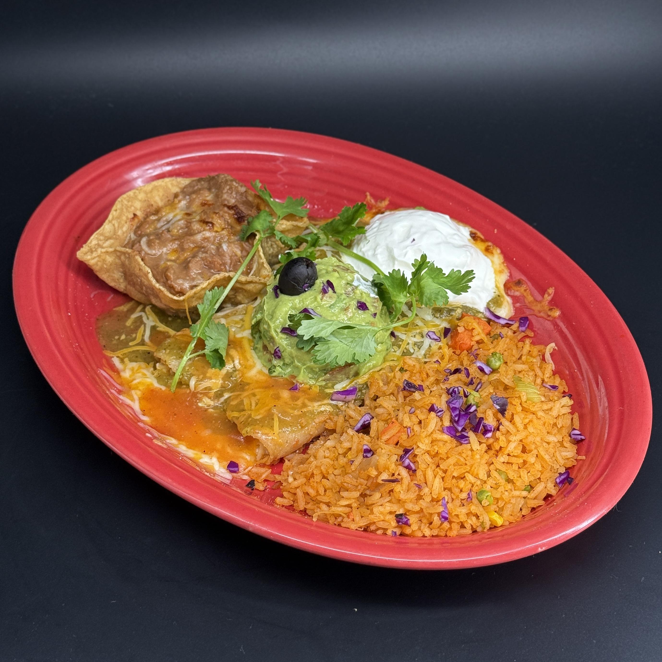 Enchiladas Rancheras- Two cheese-stuffed enchiladas, generously smothered with our homemade salsa verde and rich ranchera sauce. Each enchilada is baked until the cheese is perfectly melted, and the sauces fuse to create an irresistible blend of tastes. The enchiladas are then topped with a dollop of cool, creamy sour cream and served with a side of our homemade guacamole, frijoles, and Mexican rice.