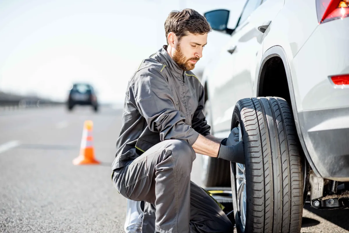 Male technician changing tire