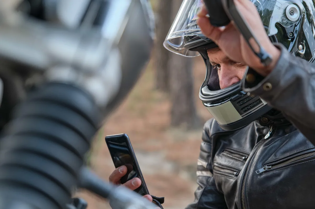 man wearing a motorcycle helmet making a call