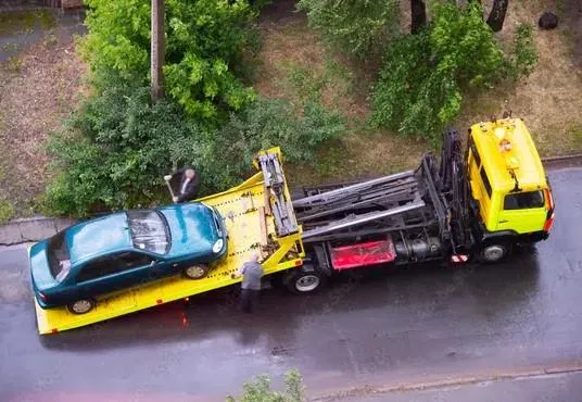 overhead shot of tow truck with a  car loaded on the flatbed on the streets of peoria illinois