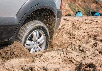 Car tire stuck in the mud trying to get out