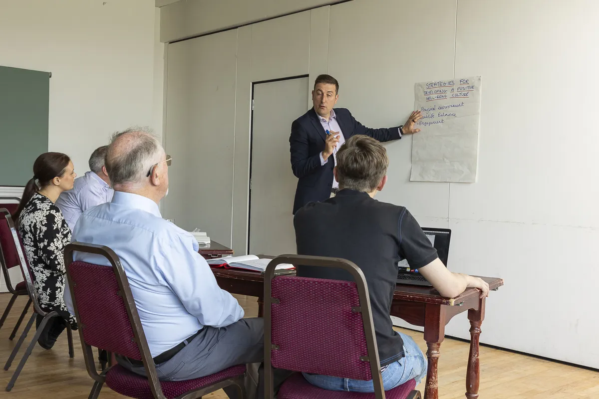 Nick Whitehouse leading a trauma-informed training session at a flipchart