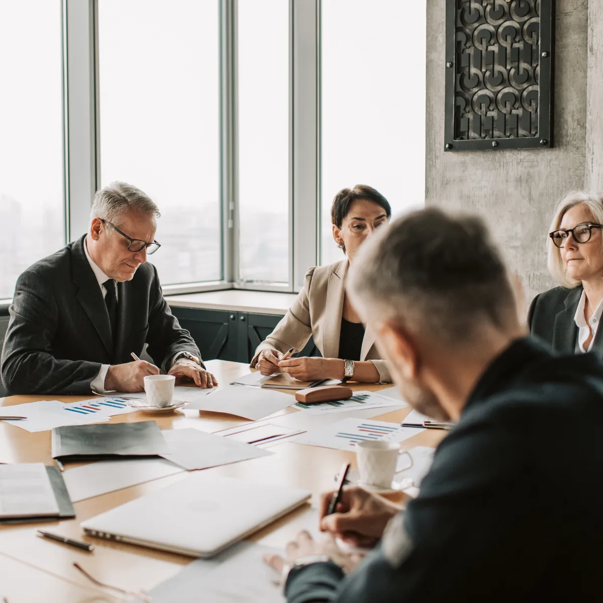 Executive team works around a table writing on paper