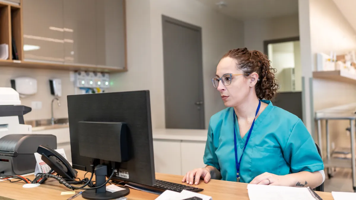 A healthcare worker sending feedback to her leadership team on a computer