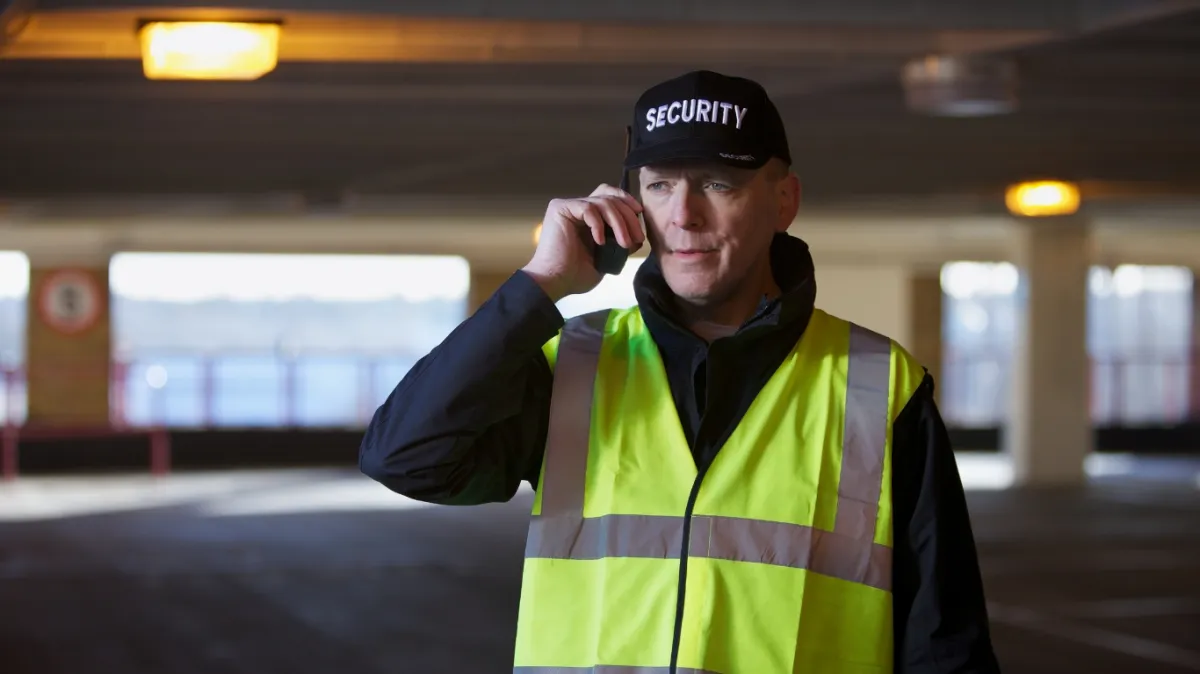 A security officer providing a verbal back brief to their supervisor on a walkie talkie