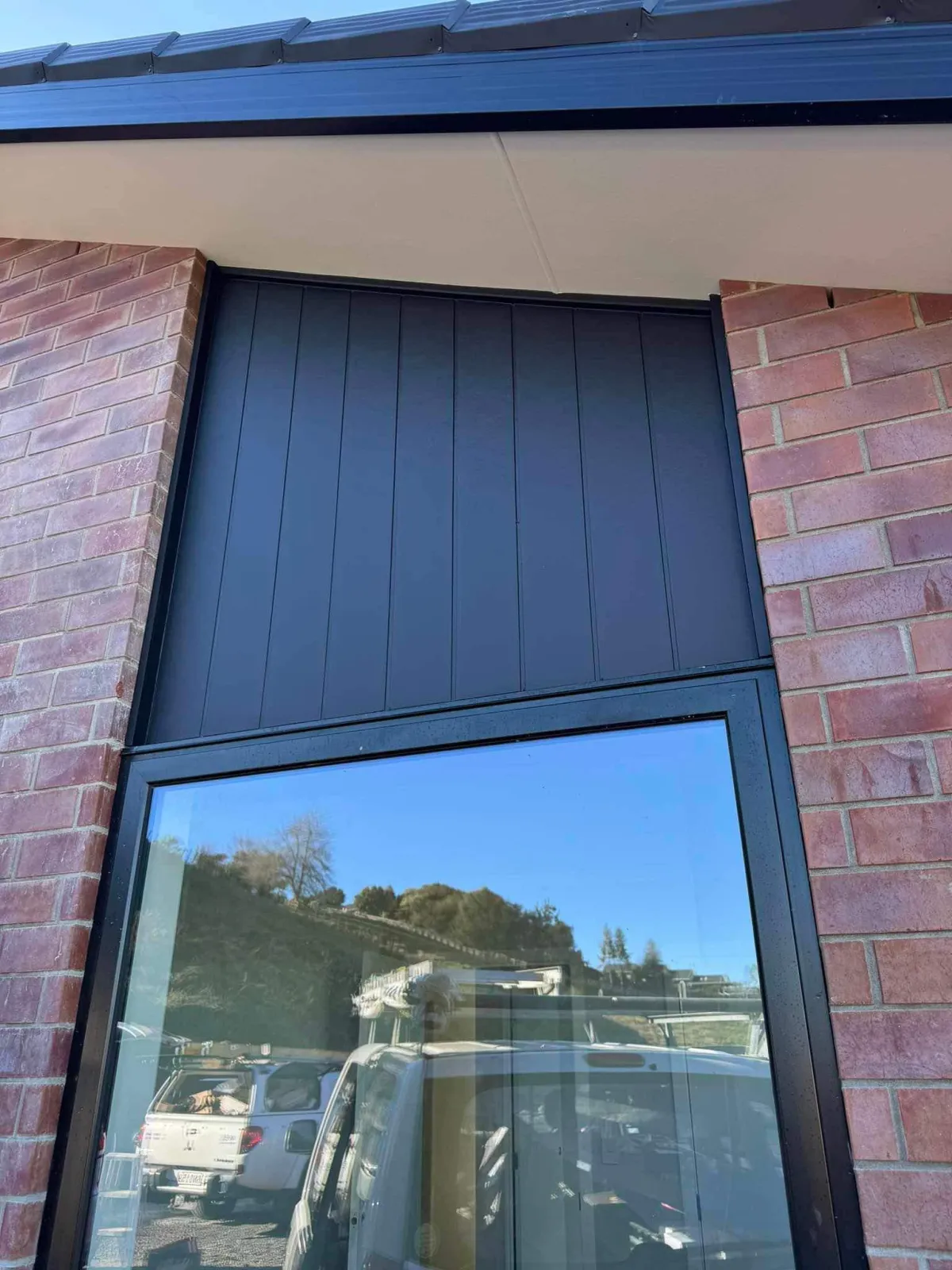 Fresh exterior wall paint with vertical paneling on a brick home in Hamilton