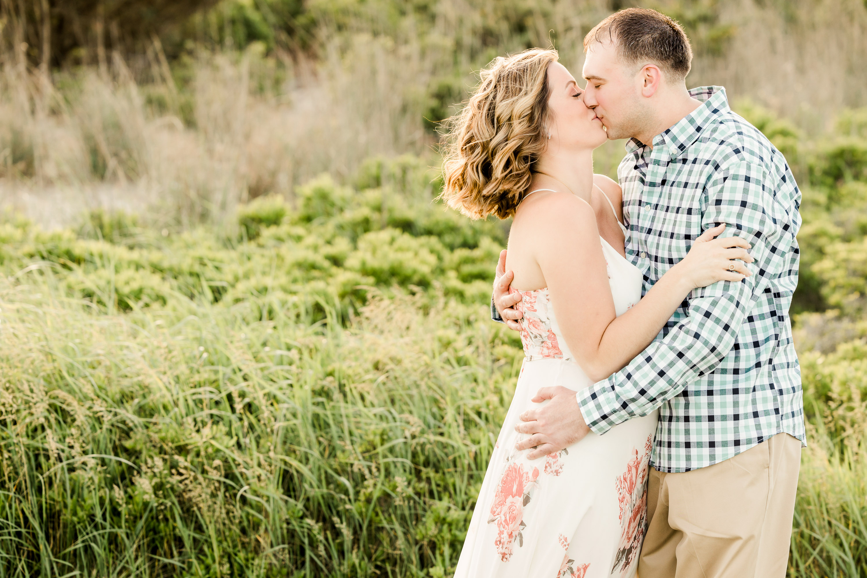 romantic engagement photos at White Rock Lake Dallas with couple kissing in natural greenery photographed by Dallas engagement photographer Lotus Wedding Photography