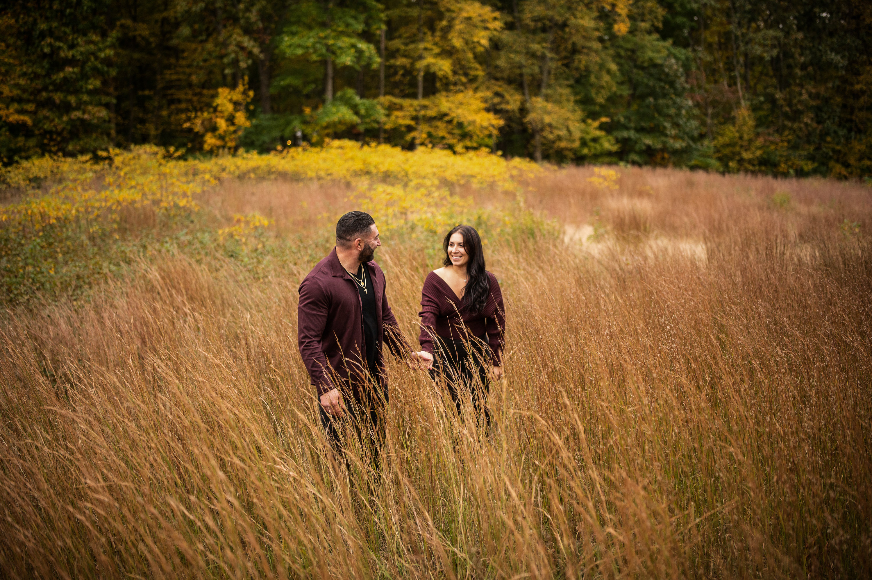 couple walking through tall grass during engagement photos at Arbor Hills Nature Preserve Dallas photographed by Dallas engagement photographer Lotus Wedding Photography