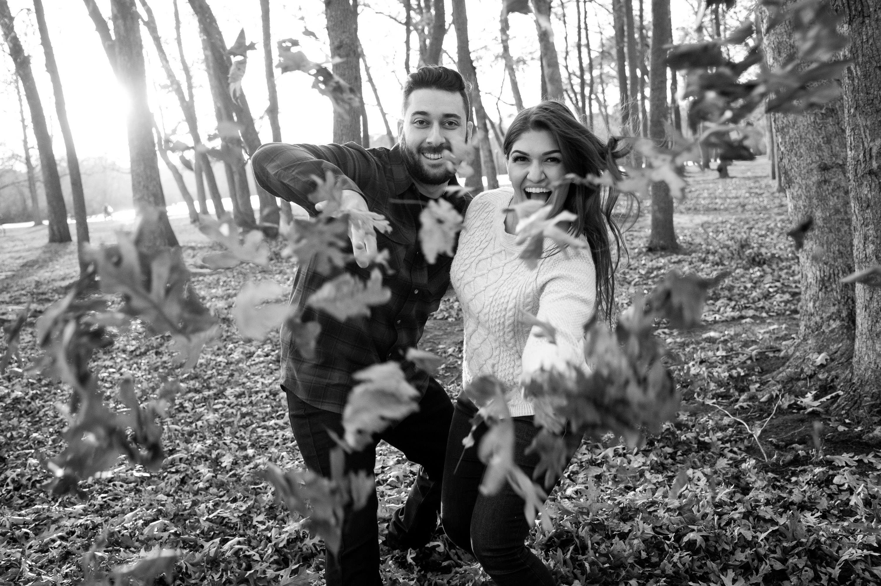 playful fall engagement photos with couple throwing leaves at White Rock Lake Dallas photographed by Dallas engagement photographer Lotus Wedding Photography
