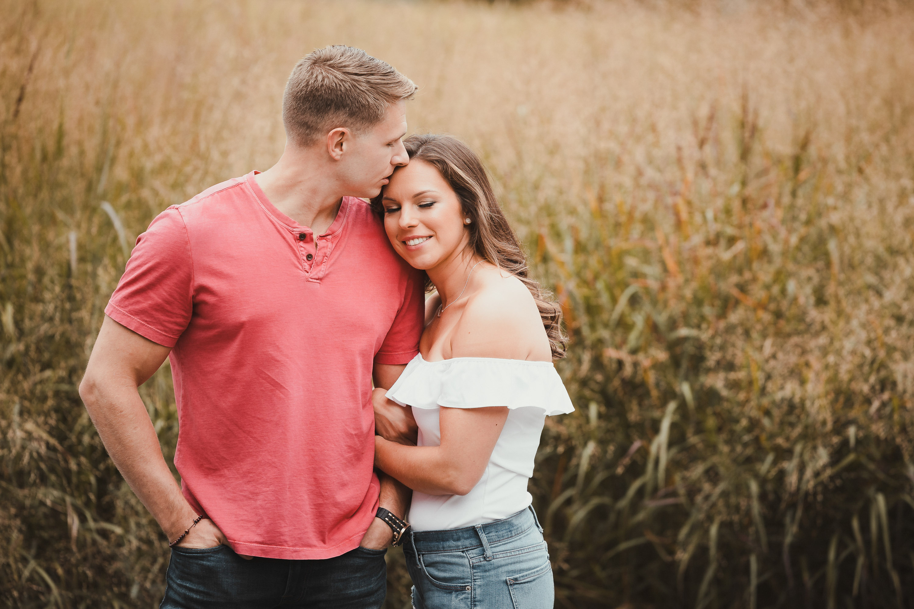 couple embracing in a golden field during engagement photos in Dallas Texas photographed by Dallas engagement photographer Lotus Wedding Photography