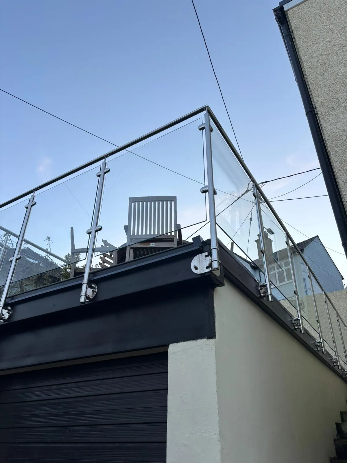 Glass balustrade installation in Anglesey using stainless steel posts. Ideal for coastal properties needing durability and modern design.